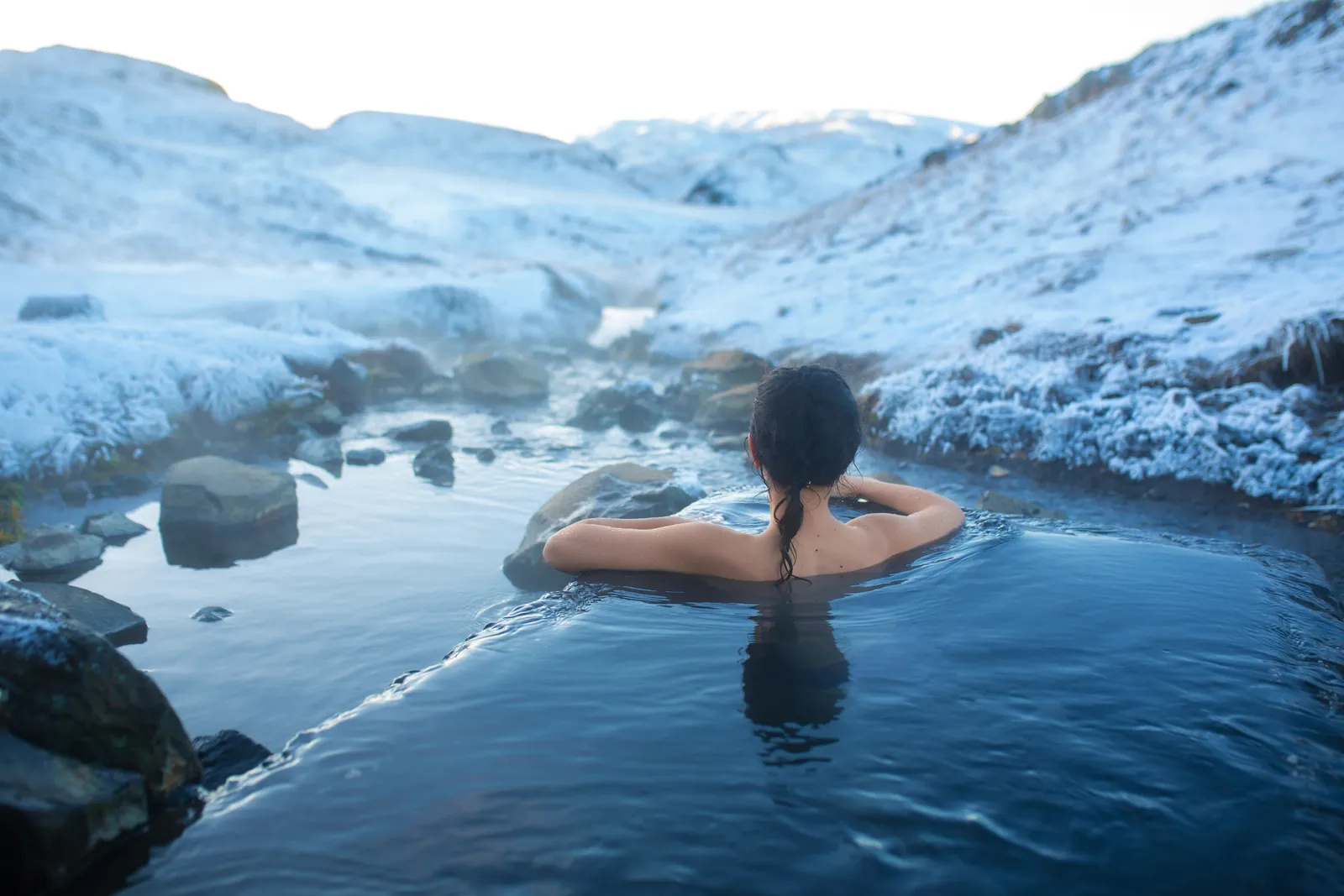 Bathing in warm geothermal water surrounded by snow in Iceland