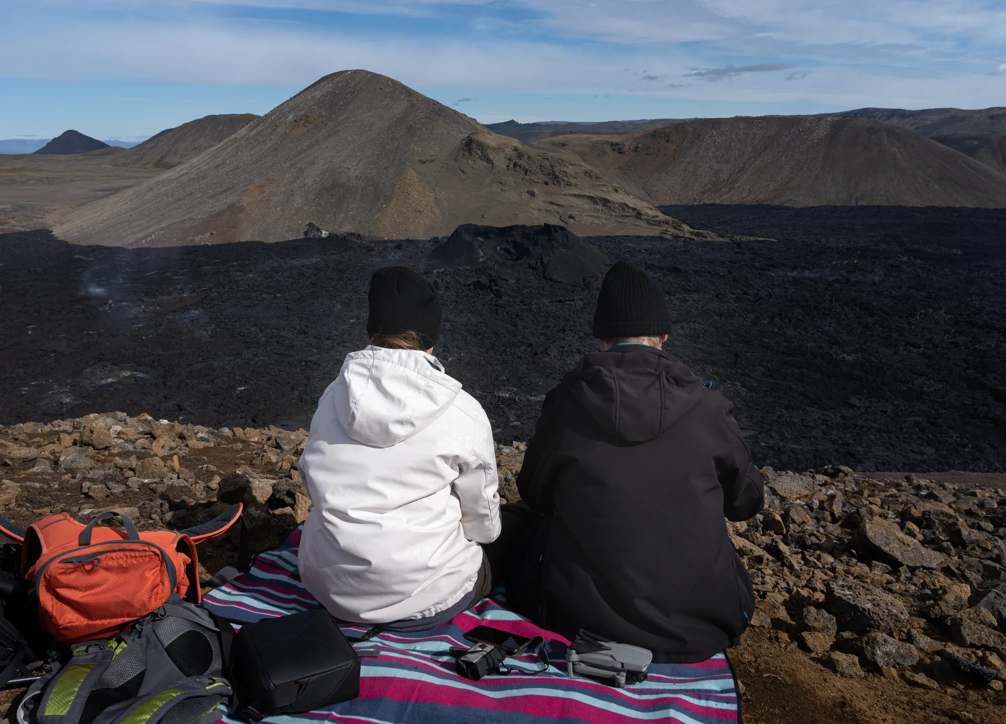 Hikers overlooking the cooled Fagradalsfjall lava fields on the Reykjanes Peninsula, the destination of Iceland's classic volcano hike