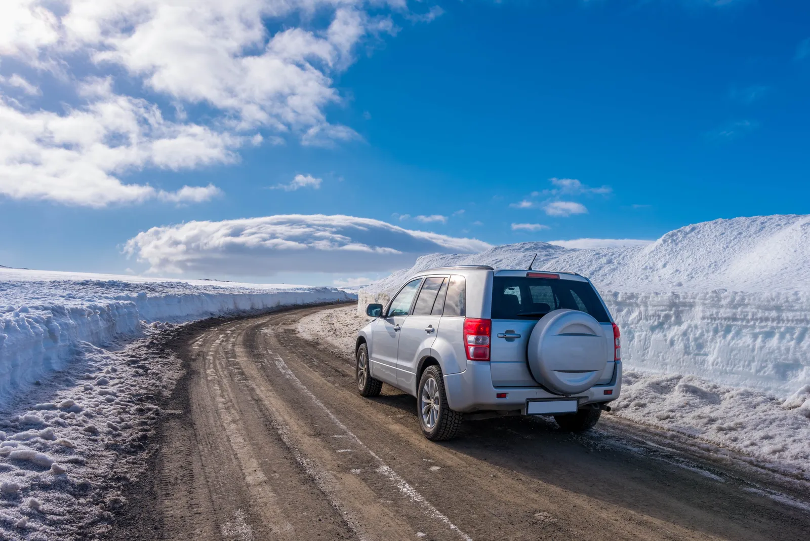 Ein Mietwagen auf einer schneebedeckten isländischen Straße im Winter — Spikereifen sind von November bis April Standard