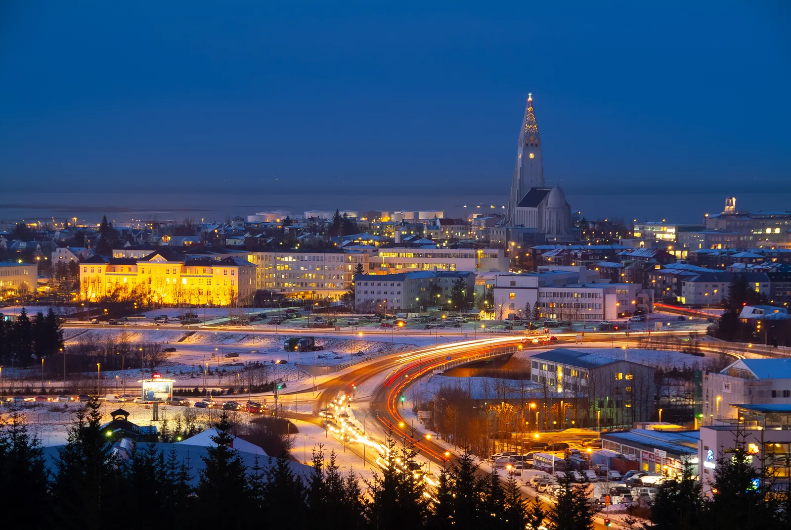Reykjavík glowing at night in winter, with Hallgrímskirkja rising above the city lights