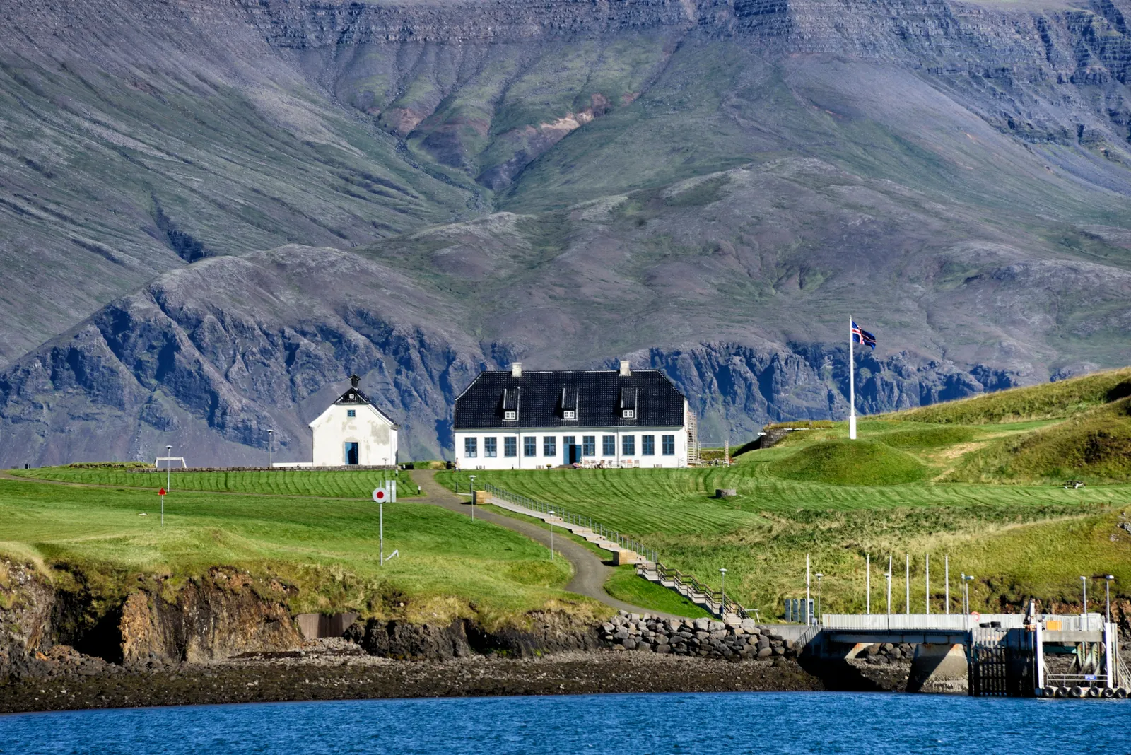 Viðey Island's 1750s stone house with Mount Esja behind — a short ferry ride from Skarfabakki