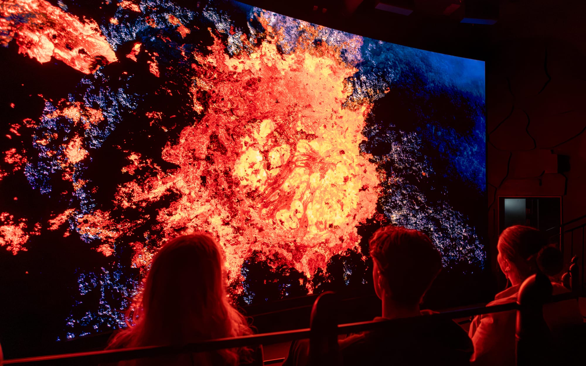Audience pointing at a lava fountain during the Volcano Express ride at Harpa